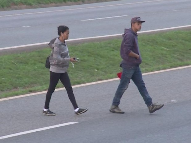 De fones de ouvido, casal atravessa a SP-127 em Tatuí (Foto: Reprodução/ TV TEM)