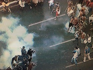 Indígena mira flecha antes de acertar perna de policial durante protesto em Brasília (Foto: Reprodução/TV Globo)