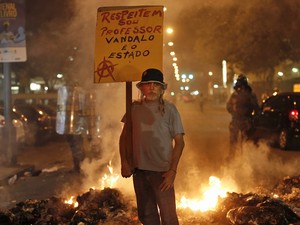 Homem carrega placa pedindo respeito durante protesto no Rio de Janeiro. (Foto: Silvia Izquierdo/AP)