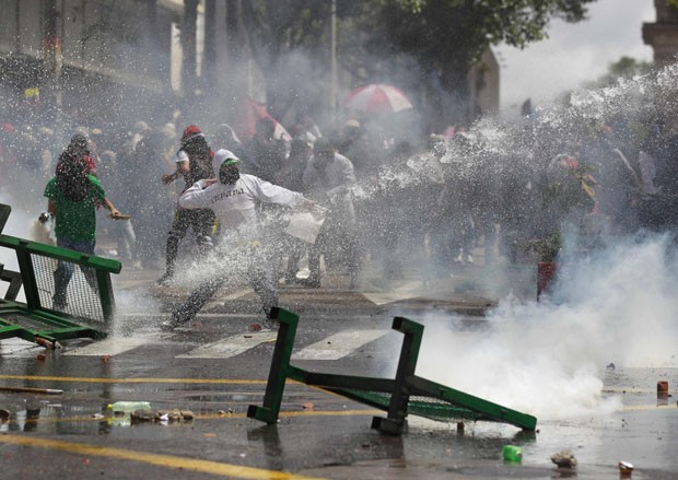 Polícia de choque tenta conter violência com jatos de água (Foto: John Vizcaino/Reuters)