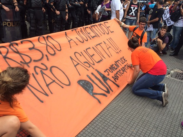 Manifestantes escrevem faixa que será carregada em protesto contra aumento da tarifa do transporte público (Foto: Glauco Araújo/G1)