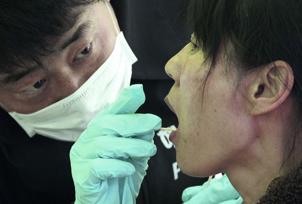 Parente de vítima de naufrágio cede amostra de DNA para identificação de corpos neste sábado (19) em Jindo, na Coreia do Sul (Foto: Ahn Young-joon/AP)