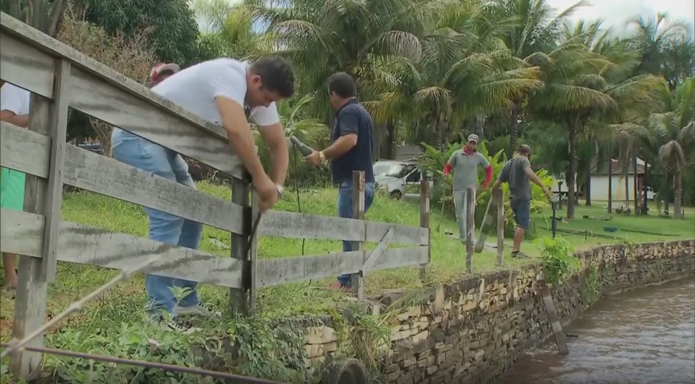 Funcionários contratados por deputado Alberto Fraga retiram cercas próximo ao lago (Foto: TV Globo/Reprodução)
