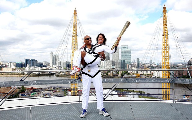 Nadia Comaneci e John Amaechi com a tocha olímpica na Greenwich Arena Londres (Foto: AP)