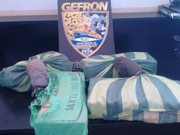 Os sacos eram carregados por dois homens, que abandonaram a carga com 40 tabletes de pasta base de cocaína (Foto: Assessoria Gefron MT) Os sacos eram carregados por dois homens, que abandonaram a carga com 40 tabletes de pasta base de cocaína (Foto: Assessoria Gefron MT)