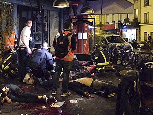 Corpos de mortos em ataque a tiros no restaurante La Belle Equipe são vistos entre mesas, com sangue na calçada em frente ao estabelecimento em Paris (Foto: Anne Sophie Chaisemartin via AP)