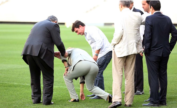 Dilma se desequilibra e quase cai ao se abaixar para checar a grama da Arena Corinthians (Foto: Marcos Ribolli)