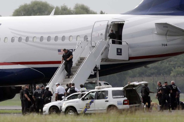 O avião da US Airways é inspecionado por policiais após ligação com falsa denúncia sobre explosivos a bordo (Foto: Matt Rourke / AP)