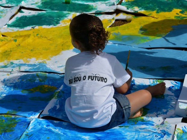 Criança com mensagem por um futuro melhor participa de pintura (Foto: Wilson Dias / Agência Brasil)