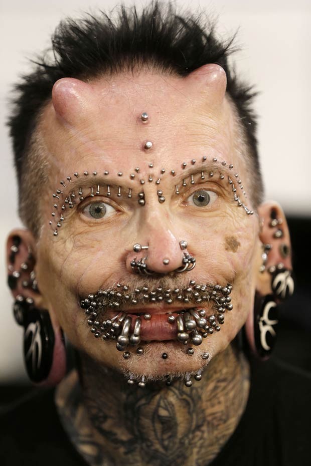 Na testa, Rolf Buchholz tem implantes que lembram chifres e um piercing entre eles (Foto: Thanassis Stavrakis/AP)