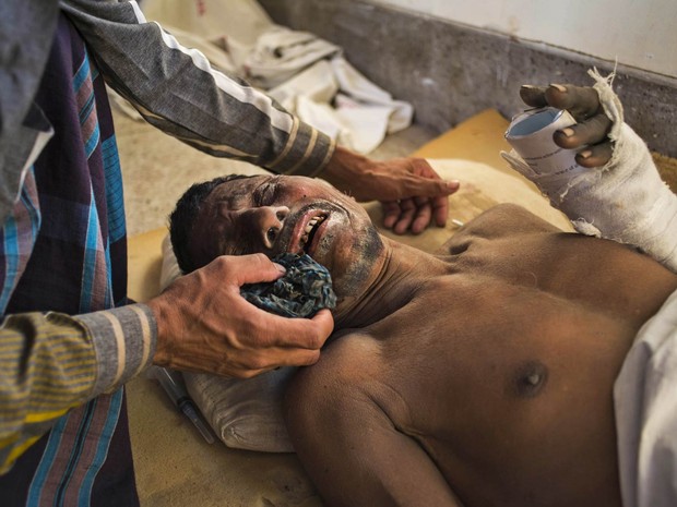 Homem chora enquanto é socorrido em um hospital de Khulna, em Bangladesh, após se ferir no desabamento de uma fábrica de cimento. Cinco trabalhadores morreram e seis ficaram gravemente feridos na queda do prédio de cinco andares (Foto: Shaikh Mohir Uddin/AP)