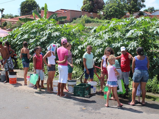Moradores formam fila para pegar água em horta comunitária do bairro Promorar (Foto: Gil Oliveira/G1)