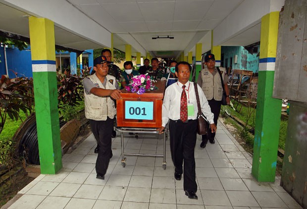 Equipes carregam caixão com corpo de vítima da queda do avião da AirAsia nesta quarta-feira (31) em um hospital de Pangkalan Bun (Foto: AFP)
