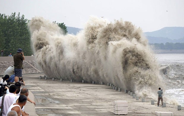 Cinegrafista se arriscou para filmar de perto as fortes ondas às margens do rio Qiantang (Foto: Reuters)