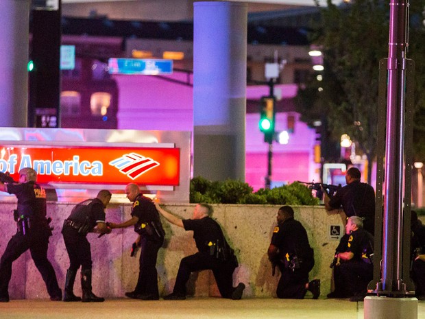 Policiais se protegem após tiros serem disparados durante uma manifestação contra a violência policial contra negros, no centro de Dallas, no Texas, nos Estados Unidos. Um homem abriu fogo contra a polícia, matando 5 e ferindo outros sete  (Foto:  Smiley N. Pool/The Dallas Morning News/Reuters)