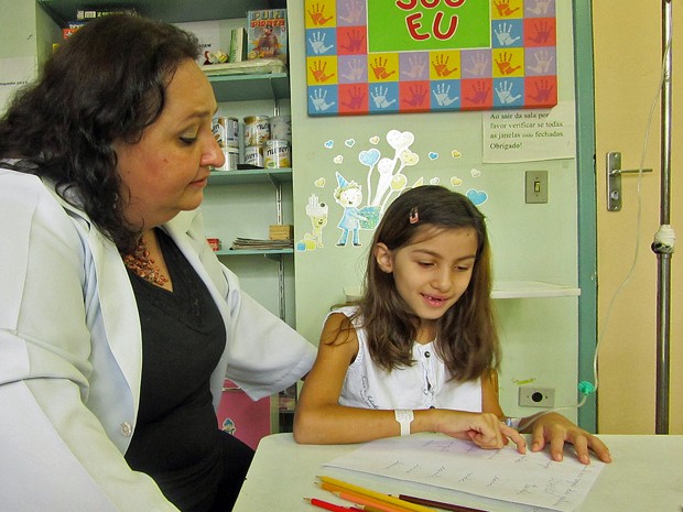 Professora Marta atende individualmente Isabelly em suas atividades (Foto: Gabriela Gonçalves/G1)