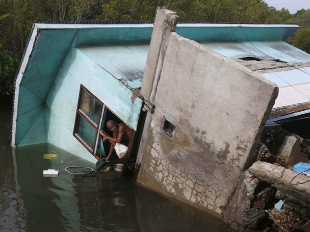 16/10 - Morador que teve a casa tombada para dentro de um rio após o terremoto da véspera atingir Buenavista, na região de Bohol, observa o exterior em meio à água (Foto: Erik de Castro/Reuters)