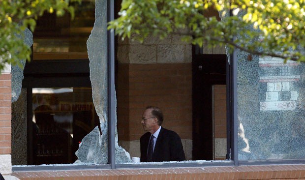 O promotor Bruce Kaplan, de Middlesex, é visto entre as janelas quebradas do mercado Pathmark (Foto: Julio Cortez/AP)