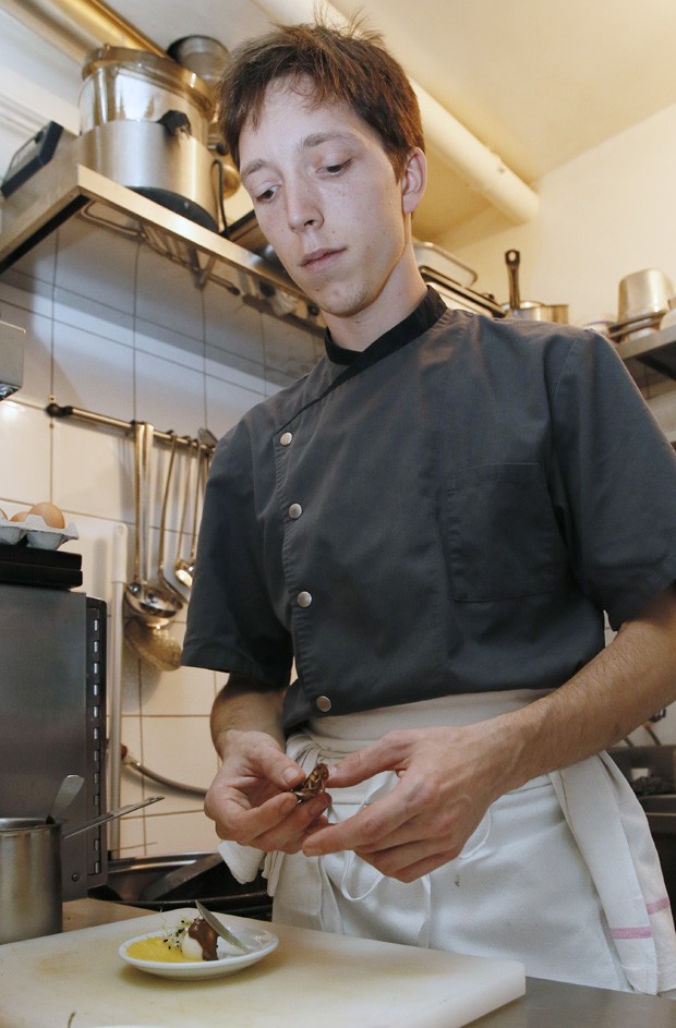 Chef Elie Daviron é clicado enquanto prepara um prato gourmet com gafanhotos (Foto: Patrick Kovarick/AFP)