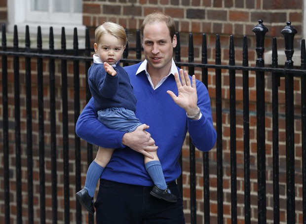O príncipe William chega ao hospital St Mary&#39;s, onde sua segunda filha nasceu neste sábado, com seu primogênito, o príncipe George (Foto: Kirsty Wigglesworth/AP)