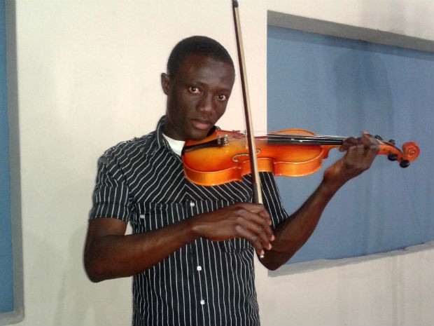 O haitiano Jean Baptiste Ilfault utiliza a música para se aproximar dos moradores de Paranavaí (Foto: Luciane Cordeiro/G1 Paraná)
