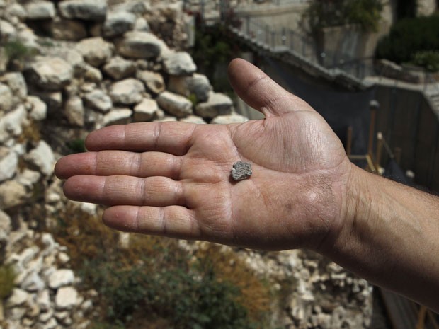 O arqueólogo israelense Eli Shukron mostra o tamanho do selo encontrado (Foto: Reuters/Baz Ratner)