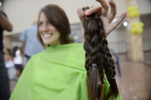 Mulher mostra seu cabelo depois de cortá-lo para doar em campanha a favor de pessoas com câncer. (Foto: AFP Photo/Leo Ramirez)