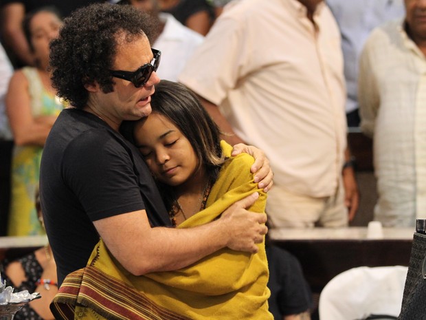 Maestro Forró abraça a filha caçula de Naná Vasconcelos, Luz Morena, no velório que acontece na Alepe nesta quarta-feira (9) (Foto: Aldo Carneiro / Pernambuco Press)