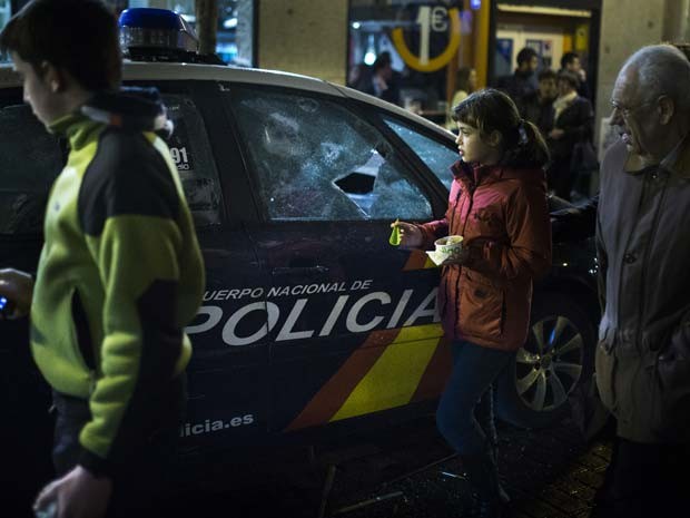 Vidro de carro da polícia foi quebrado durante manifestação neste sábado (21) em Madri (Foto: AP Photo/Andres Kudacki)