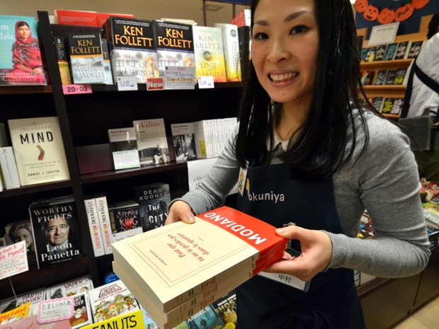 Funcionário de livraria em Tóquio, no Japão, destaca livros do vencedor do Nobel de Literatura, Patrick Modiano, nas prateleiras (Foto: AFP PHOTO/Yoshikazu TSUNO )