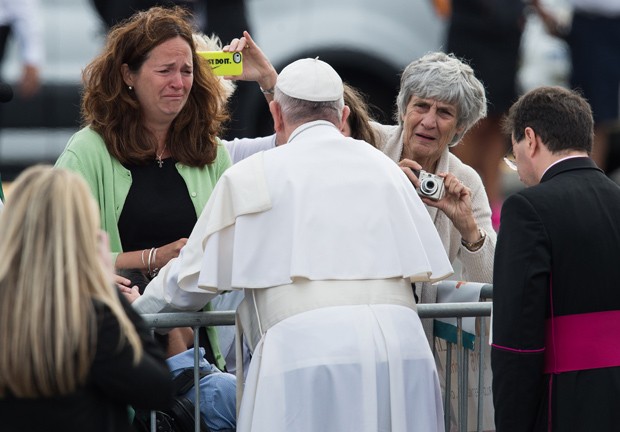  Mulher chora ao ver papa Francisco se aproximar e abençoar seu filho com deficiência física em sua chegada à Filadélfia (Foto: Nicholas Kamm/AFP)