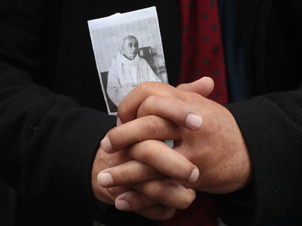 Pessoa segura foto do padre Jacques Hamel em seu funeral na Catedral de Rouen (Foto: Joel Saget/AFP)