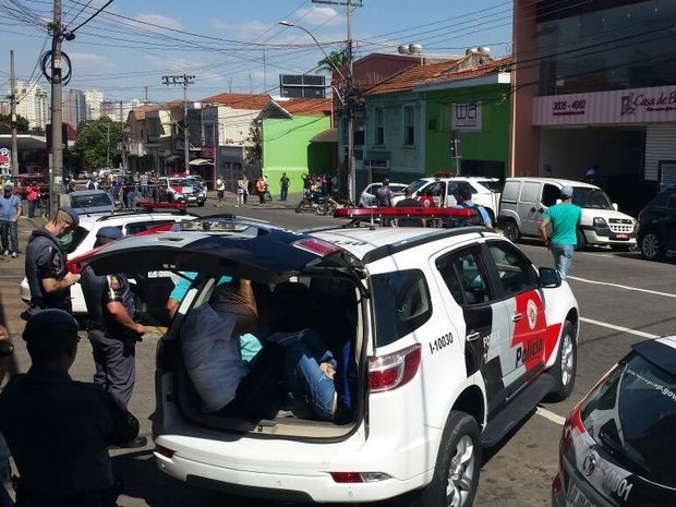 Suspeitos são colocados em carro da PM após tentativa de assalto a banco em Piracicaba (Foto: Claudia Assencio/G1)