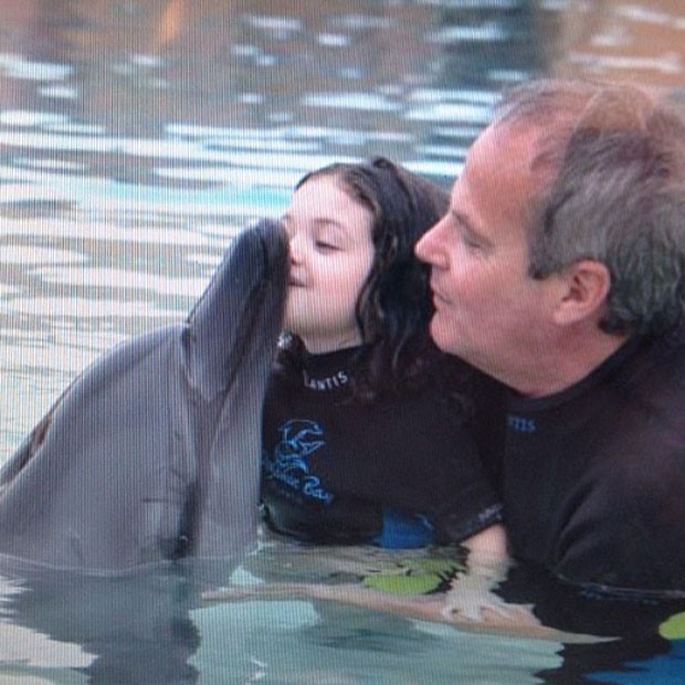 Jayme Monjardim segura a filha para dar beijo em golfinho (Foto: Instagram)