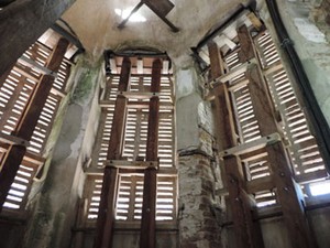 Foto mostra interior da torre com fissuras na alvenaria e escoramento provisório de madeira. (Foto: Luna Markman/G1)