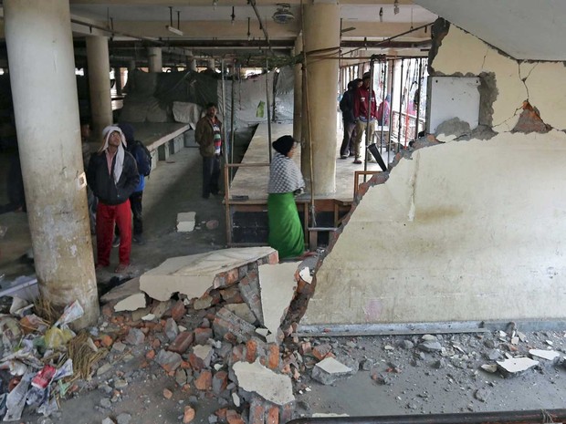Pessoas em um edifício danificado em Imphal (Foto: Reuters)