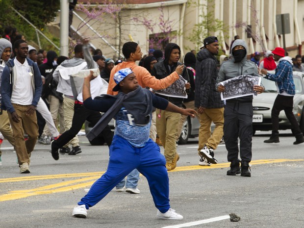 Manifestantes atiram pedras na polícia após o funeral de Freddie Gray, na Igreja Batista New Shiloh, em Baltimore, na segunda (27)  (Foto: AP Photo/Jose Luis Magana)