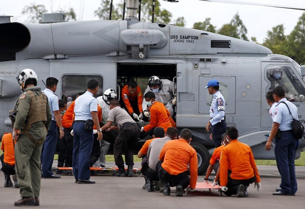 Corpos de vítimas são retirados de helicóptero da Marinha dos EUA que trabalha nas buscas pelo avião da AirAsia nesta sexta-feira (2) (Foto: Darren Whiteside/Reuters)