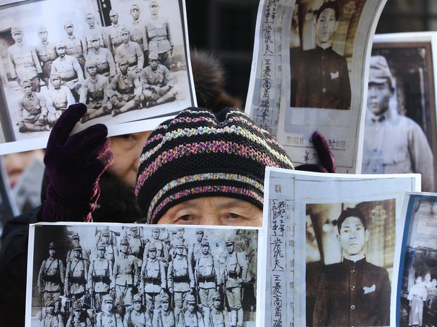 Familiares de vítimas seguravam cartazes em frente ao Ministério sul-coreano das Relações Exteriores (Foto: AP Photo/Ahn Young-joon)
