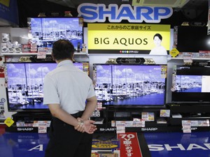 Homem observa televisores da Sharp em uma loja de eletrônicos em Tóquio (Foto: Reuters) Homem observa televisores da Sharp em uma loja de eletrônicos em Tóquio (Foto: Reuters)