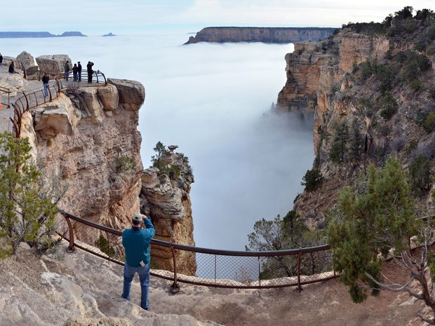 Turistas observma fenômeno que encobre paisagem do Grand Canyon. (Foto: AP Photo/National Park Service, Maci MacPherson)