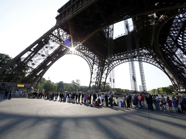 Turistas esperam em fila embaixo da Torre Eiffel, fechada pelo segundo dia por causa de greve (Foto: Gonzalo Fuentes/Reuters)