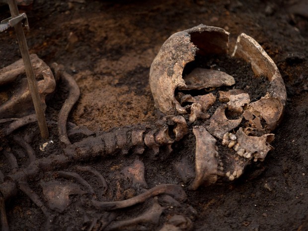 Um esqueleto é visto durante uma escavação arqueológica em Londres, na Inglaterra. A equipe estima ter cerca de 3 mil esqueletos humanos no local, que era utilizado para enterrar pacientes do hospital Bedlam, o primeiro hospital psiquiátrico do mundo (Foto: Matt Dunham/AP)