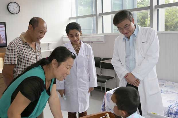 Foto tirada no dia 9 de setembro mostra médicos consultando o menino chinês que teve os olhos arrancados em um hospital em em Shenzhen, no sul da China (Foto: C-MER Dennis Lam Eye Hospital/ AFP)