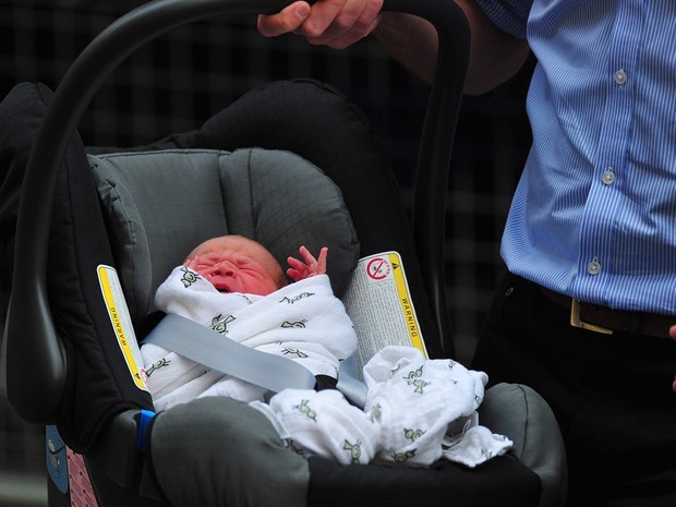 William carrega seu filho George para dentro do carro ao deixar o hospital em 2013 (Foto: Carl Court/AFP)