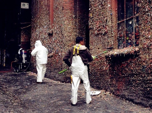 Limpeza das paredes cobertas de chicletes multicoloridos
