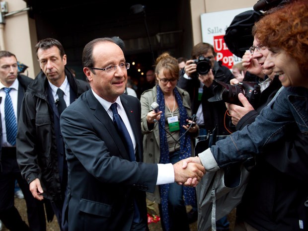 O presidente francês François Hollande cumprimenta eleitores enquanto depois de votar no primeiro turno das eleições legislativas que acontecerem neste domingo (10) (Foto: Bertrand Langlois/ FP)