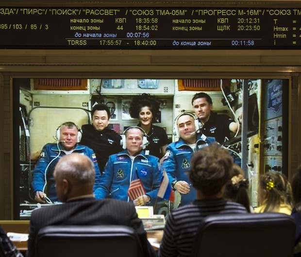 Equipe do centro de controle da missão ISS, localizado em Korolev, na Rússia, conversa com os tripulantes da Estação. Na frente, vestidos de azul, os astronautas recém-chegados; atrás, os tripulantes mais antigos (Foto: AP Photo/NASA,Bill Ingalls) Equipe do centro de controle da missão ISS, localizado em Korolev, na Rússia, conversa com os tripulantes da Estação. Na frente, vestidos de azul, os astronautas recém-chegados; atrás, os tripulantes mais antigos (Foto: AP Photo/NASA,Bill Ingalls)