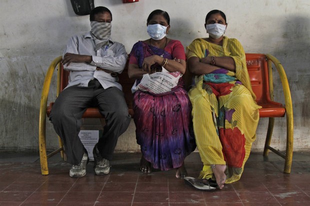 Parentes de pessoas infectadas pela gripe H1N1, na Índia, esperam do lado de fora de área de isolamento do Hospital Civil em Ahmadabad  (Foto: AP Photo/Ajit Solanki)