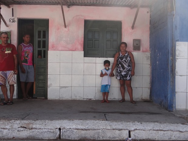 Família do garoto em frente a casa onde moram  (Foto: Marcio Chagas/G1)